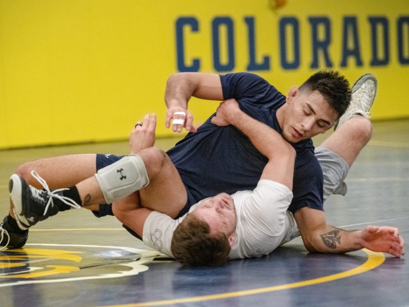 Two men wrestle in a gym