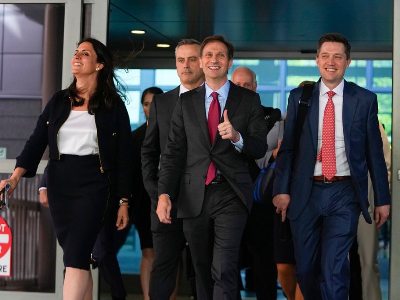 A group of people walking down a hallway.