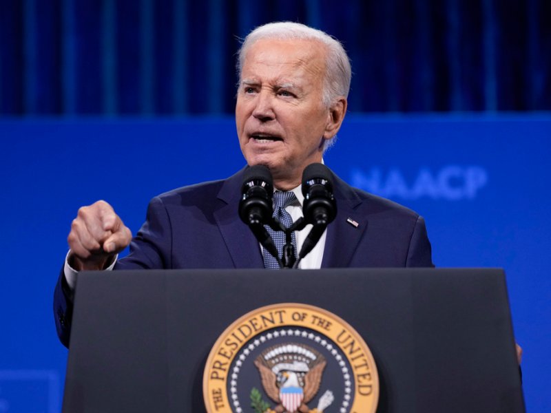 President Joe Bieden speaks at a podium with the presidential seal, against a blue background with "NAACP" partially visible.