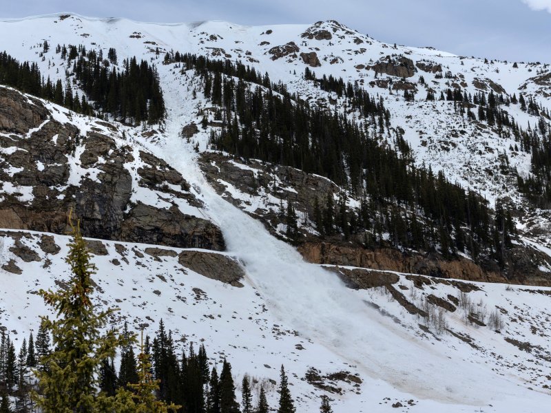 An avalanche falls over a road.