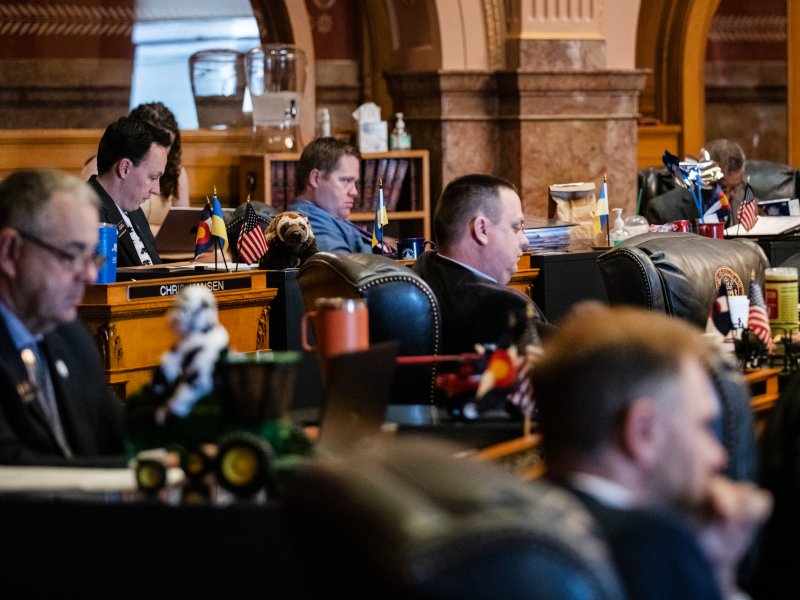 Lawmakers in suits sitting inside the Colorado capitol