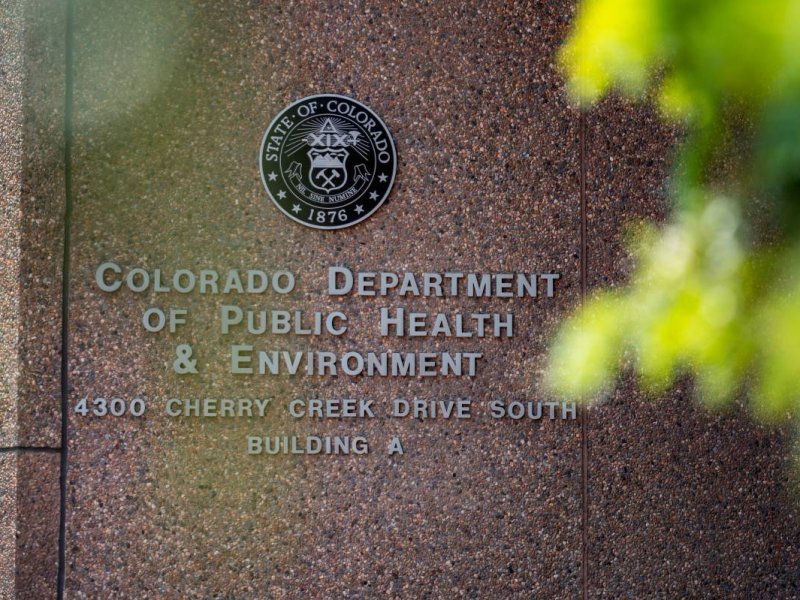 Signage for the Colorado Department of Public Health and Environment, located at 4300 Cherry Creek Drive South, Building A, with the state emblem above the text.