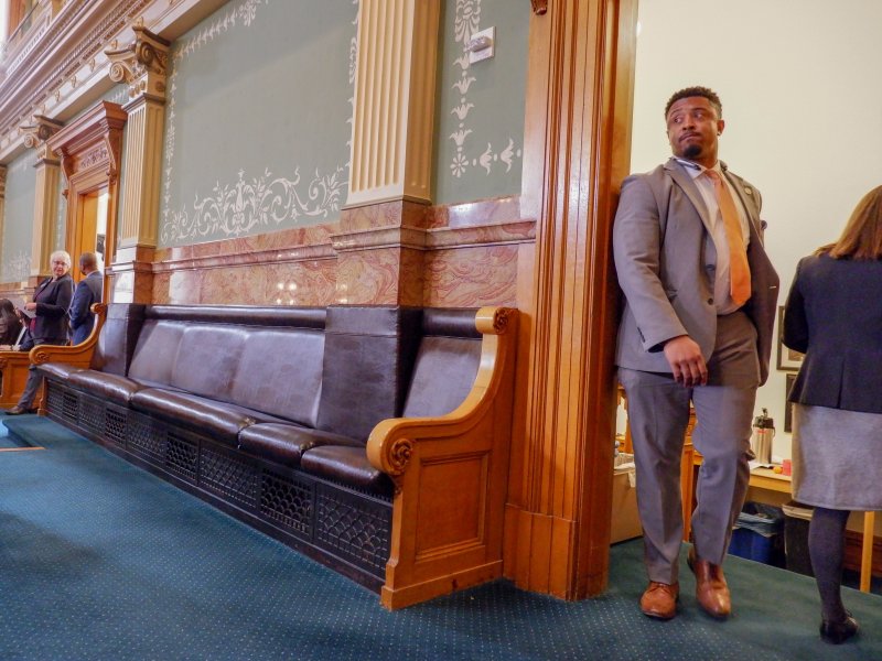 James Coleman in a suit walks through a doorway inside the Colorado Capitol.