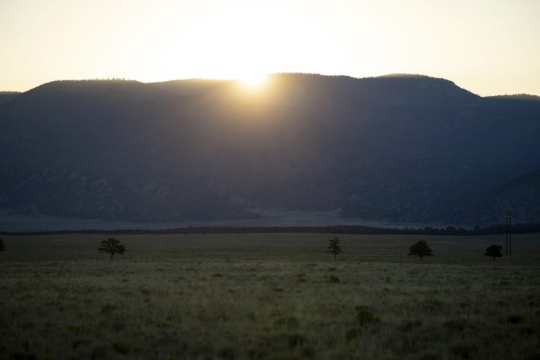 The morning sun peaks above the mountain