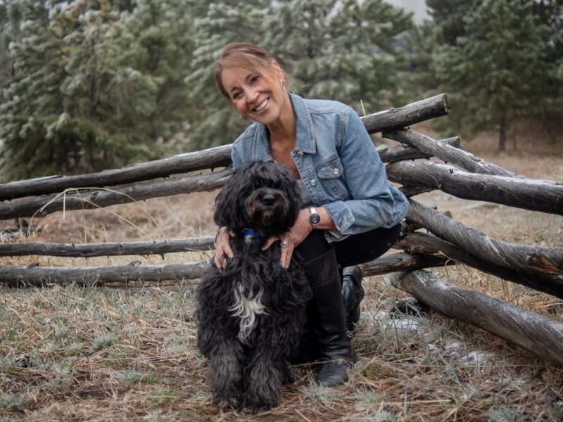 Joyce Vanek poses for a picture with a Portuguese water dog while outside