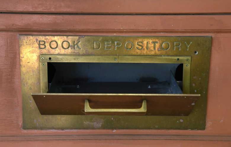 An open book drop outside a library labeled "BOOK DEPOSITORY."