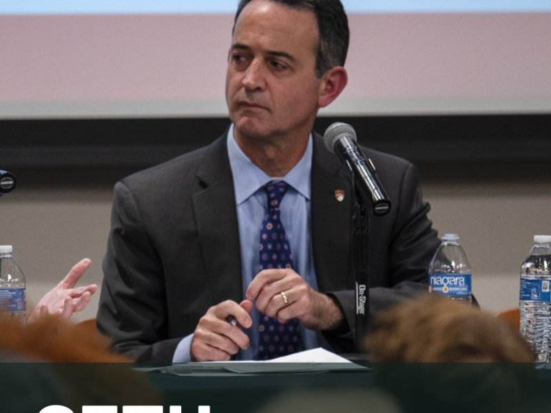 Seth Masket, in a suit, sits at a table with microphones and water bottles, under a projection screen displaying the CBS logo and the number 4. Text on the image reads "Seth Masket, DU Political Scientist.