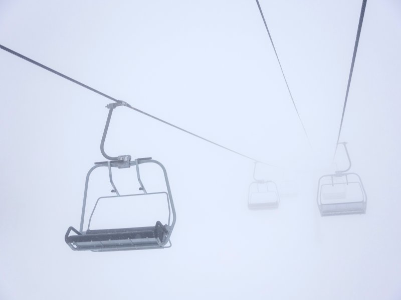 Chairs on a ski lift run in a snow storm