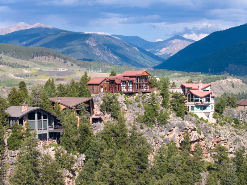 homes in a forest with mountains in background