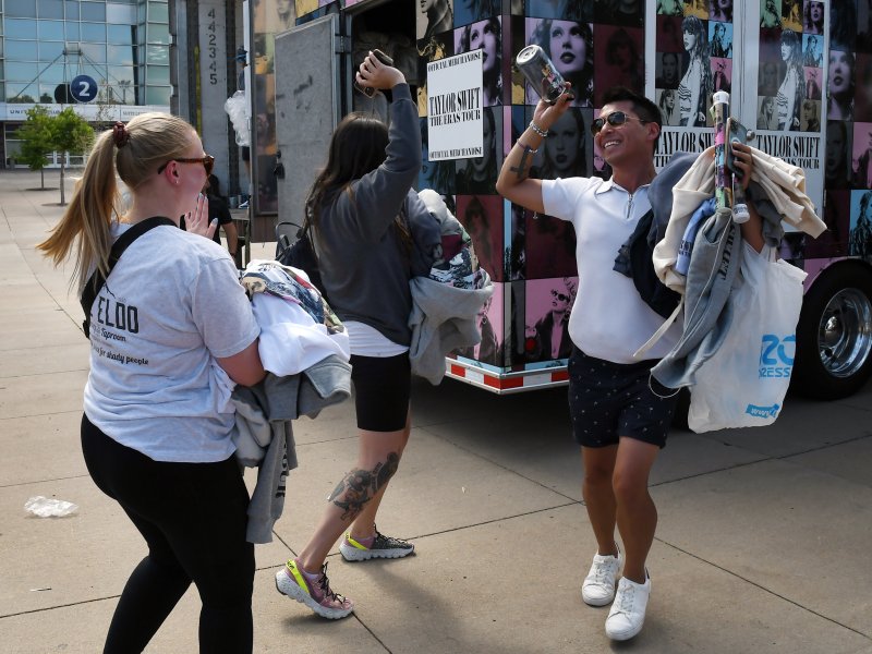 Fans hold up merch and celebrate together