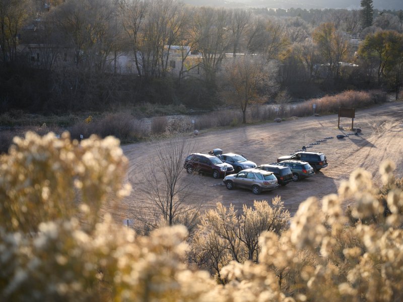 A group of cars parked on a dirt road.