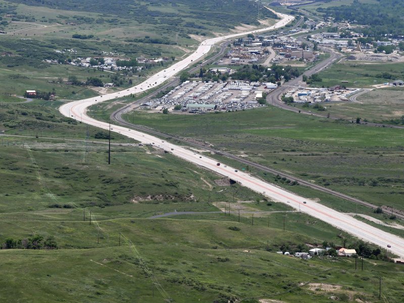 Aerial view of powerlines next to a road and a cluster of buildings