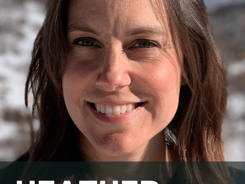 Portrait of a woman with long brown hair smiling at the camera, with a snowy mountain landscape in the background. Text overlay reads: "Heather Sackett, Environment Reporter.