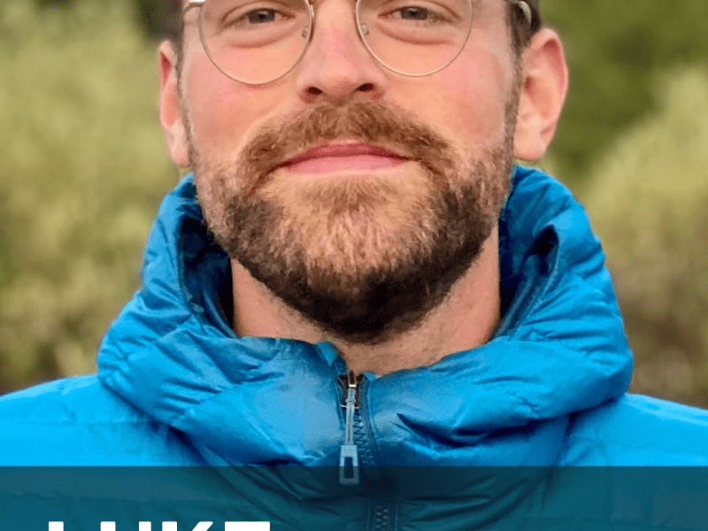 A person wearing glasses and a blue jacket stands outdoors with trees in the background. Text on the image reads, "Luke Runyon, Water and Climate Reporter.